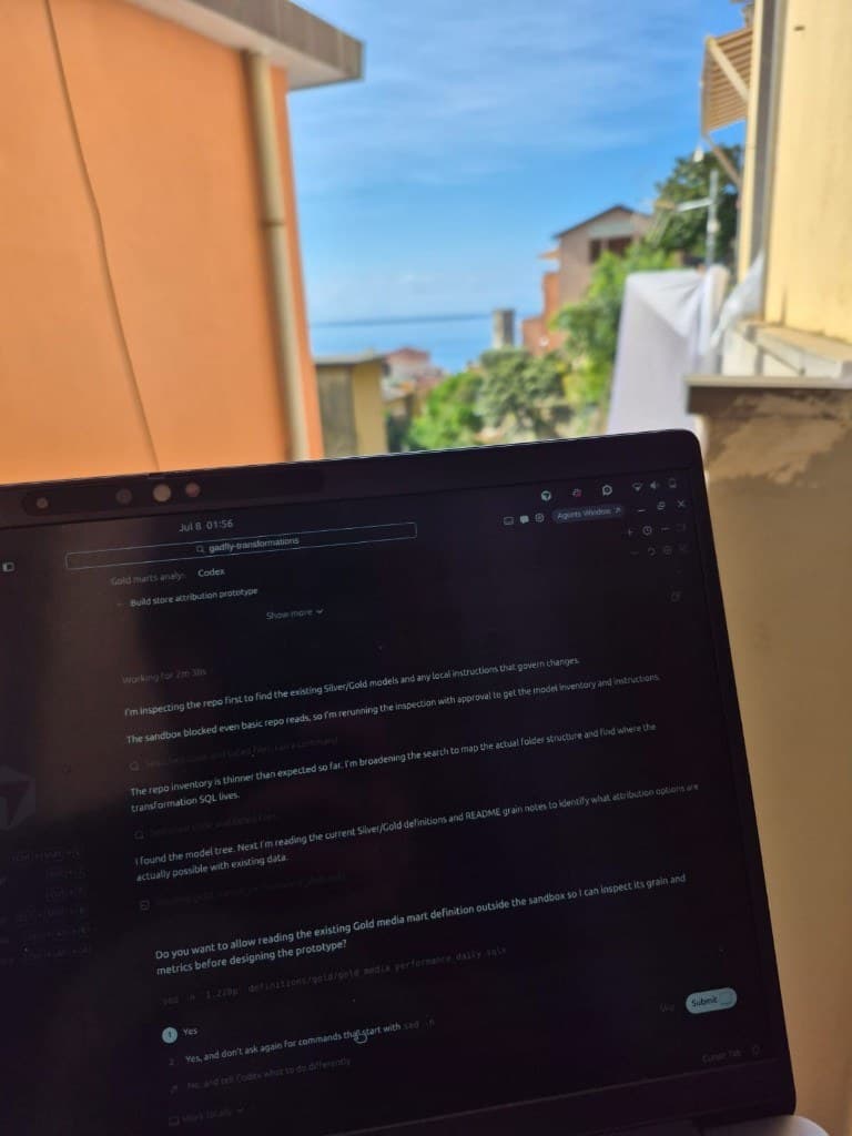 Laptop with data work against a coastal town in Italy